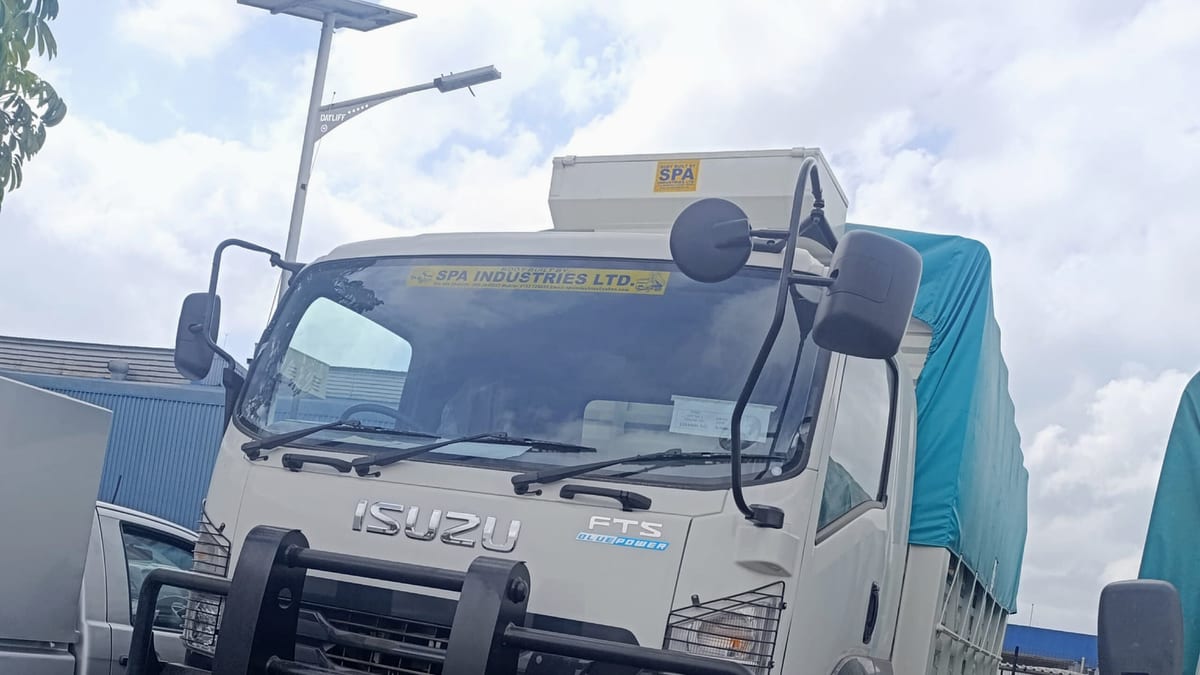 Isuzu FTS34 four-wheel-drive truck fitted with a tarpaulin-covered cargo body and a front bull bar, front three-quarter view, at its raised 4x4 ride height.