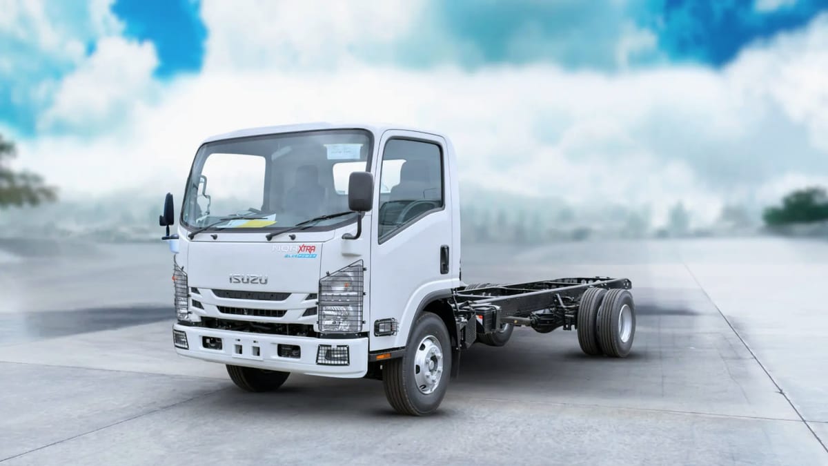 Isuzu NQR Xtra cab chassis, front three-quarter view, showing the long bare frame rails behind the cab that give the Xtra its extra body length.